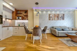 Stek Hills Zlatibor في زلاتيبور: مطبخ وغرفة معيشة مع طاولة وأريكة