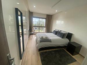 um quarto com uma cama e uma grande janela em Luxueux appartement avec vue panoramique em Mohammedia