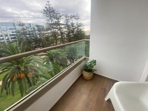 a balcony with a white table and palm trees at Luxueux appartement avec vue panoramique WELCOME STAY in Mohammedia +82 photos
