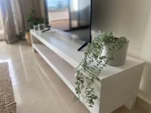 a white dresser with a potted plant on it at Luxueux appartement avec vue panoramique in Mohammedia