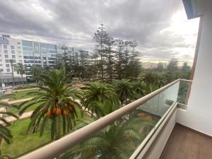 a balcony with a view of palm trees and buildings at Luxueux appartement avec vue panoramique WELCOME STAY in Mohammedia