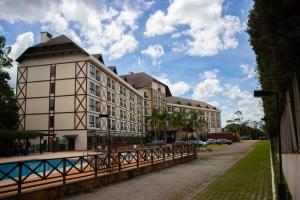 a large building with a fence in front of it at Loft 335 Vista Azul- De frente para a Pedra Azul in Pedra Azul