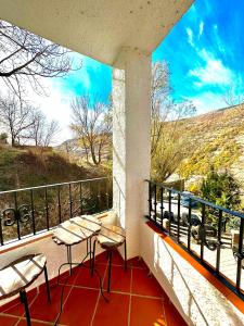 Un balcón con mesas y sillas y vistas. en Apartamentos Vista Veleta, en Capileira