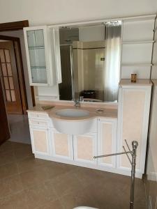 a bathroom with a sink and a mirror at Appartamento Il Giardino in Castello dellʼAcqua