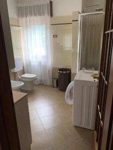 a bathroom with a toilet and a sink and a shower at Appartamento Il Giardino in Castello dellʼAcqua