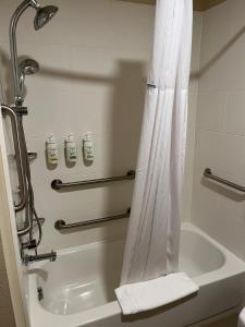 a bathroom with a tub and a shower with a shower curtain at Wingate by Wyndham Pittsburgh West Mifflin in West Mifflin