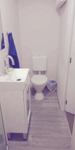 a white bathroom with a toilet and a sink at Modest comfortable relaxed home away from home in Rotorua