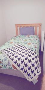 Cama pequeña con edredón azul y blanco en Modest comfortable relaxed home away from home en Rotorua