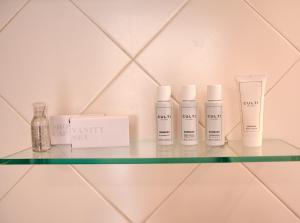 a shelf with four bottles of moisturizers on it at Villa Margherita in Naples