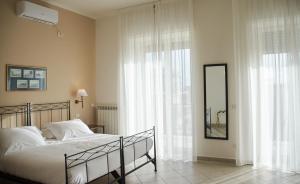 a bedroom with a bed and a large window at Villa Margherita in Naples