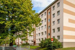 un edificio alto con una señal roja delante de él en Cute Tammsaare Beach Apartment, en Pärnu