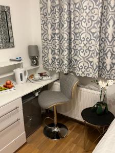 a room with a desk and a chair and a curtain at TJ Homes - Double room with Single Bed - 3 Min to Tube station - London in Ruislip