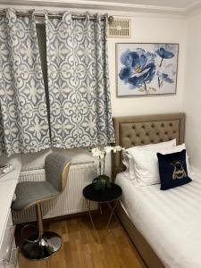 1 dormitorio con 1 cama, 1 silla y 1 ventana en TJ Homes - Double room with Single Bed - 3 Min to Tube station - London en Ruislip