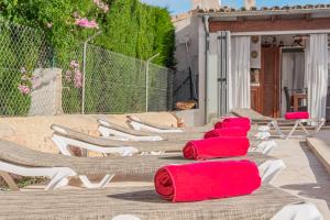 a row of lounge chairs with red towels on them at Casa Carmela in Cacla D'or