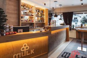 eine Bar in einem Restaurant mit einer Theke in der Unterkunft Mulk Hotel - Joker Card included in Summer in Saalbach-Hinterglemm