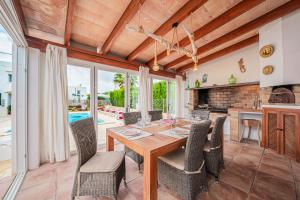a kitchen and dining room with a wooden table and chairs at Casa Carmela in Cacla D'or