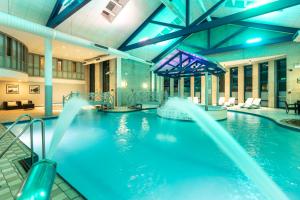 a swimming pool with blue water in a building at Gloucester Robinswood Hotel, BW Signature Collection in Gloucester