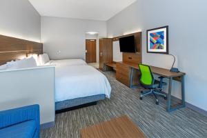 Holiday Inn Express & Suites - Houston - N Downtown, an IHG Hotel في هيوستن: غرفة في الفندق بها سرير ومكتب وبه جهاز كمبيوتر