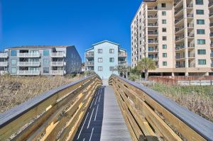 a wooden pedestrian bridge with buildings in the background at Direct Ocean Front 3BR/2BA Dog Friendly **OCEANFRONT** in Myrtle Beach
