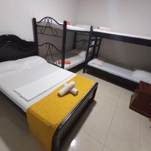Una habitación con una cama con un juguete. en Hostal Villa del Río Las Brisas en Villavieja