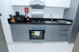 a small kitchen with a stove and a sink at DAMAC MAISON PRIVE in Dubai
