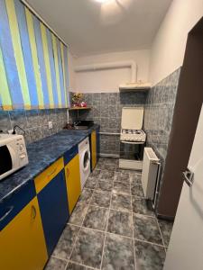a small kitchen with colorful cabinets and appliances at Comfy Condo Zalau in Zalău