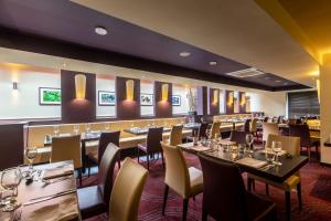 a restaurant with tables and chairs and a bar at Gloucester Robinswood Hotel, BW Signature Collection in Gloucester