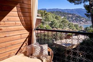 a balcony with a chair and a view of the water at Bikini Island & Mountain Port de Soller "Adults only" in Port de Soller