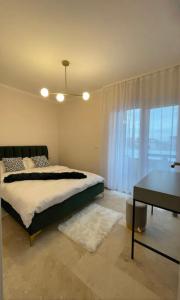 1 dormitorio con cama, escritorio y ventana en Apartamente cu un dormitor en Timisoara