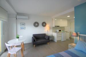 ein Wohnzimmer mit einem Sofa, einem Tisch und einem Stuhl in der Unterkunft CasaTuris Estudio vistas increíbles en Centro de Alicante A115 in Alicante