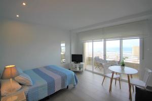 Schlafzimmer mit einem Bett und einem Tisch sowie einem Balkon in der Unterkunft CasaTuris Estudio vistas increíbles en Centro de Alicante A115 in Alicante
