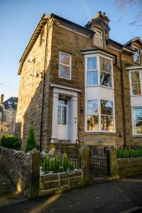 a brick house with a dog in the window at Tranquil Four Bedroom Retreat in Buxton in Buxton