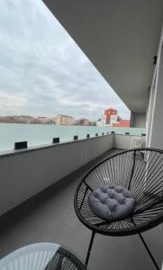 krzesło na balkonie z widokiem na wodę w obiekcie Apartamente cu un dormitor w mieście Timişoara