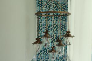 a chandelier hanging from a wall with blue tiles at V-Ocean Palace in Hat Yai