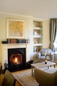 - un salon avec une cheminée, un canapé et des chaises dans l'établissement Luxurious 4 bedroom townhouse in Buxton, à Buxton