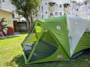 Aluguel de mini quartos e barracas no Perequê-açu de frente para o mar numero 1125 في أوباتوبا: خيمة خضراء تجلس على العشب في حقل