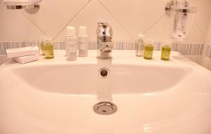 a bathroom sink with soap and bottles on it at Villa Margherita in Naples
