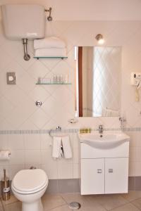 a bathroom with a toilet and a sink and a mirror at Villa Margherita in Naples