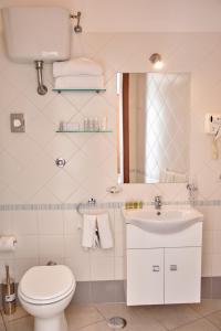 a bathroom with a toilet and a sink and a mirror at Villa Margherita in Naples