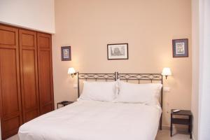a bedroom with a bed with white sheets and pillows at Villa Margherita in Naples