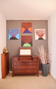 a room with three paintings on the wall and a dresser at Villa Margherita in Naples