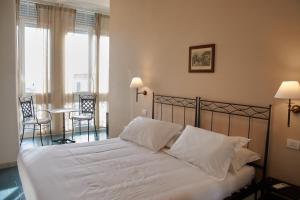 a bedroom with a bed with white sheets and pillows at Villa Margherita in Naples