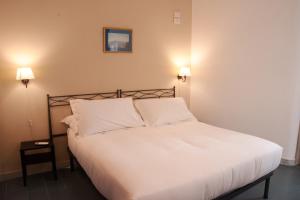 a bedroom with a bed with white sheets and two lights at Villa Margherita in Naples