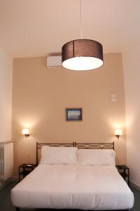 a bedroom with a white bed with a large light fixture at Villa Margherita in Naples
