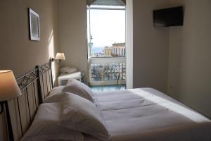 a white bed in a room with a large window at Villa Margherita in Naples