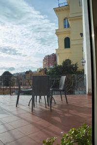 two chairs and a table on a patio with a building at Villa Margherita in Naples