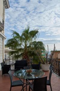 a patio with a table and chairs and a palm tree at Villa Margherita in Naples
