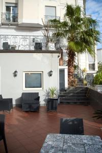 a patio with chairs and a tv on a building at Villa Margherita in Naples