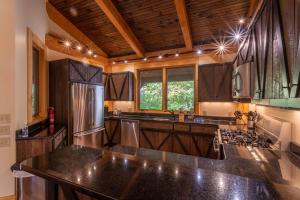 a large kitchen with wooden cabinets and a counter top at Rustic Cedar Rock Townhome at Eagles Nest in Banner Elk