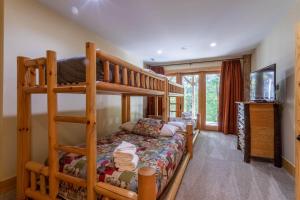 a bedroom with two bunk beds and a television at Rustic Cedar Rock Townhome at Eagles Nest in Banner Elk